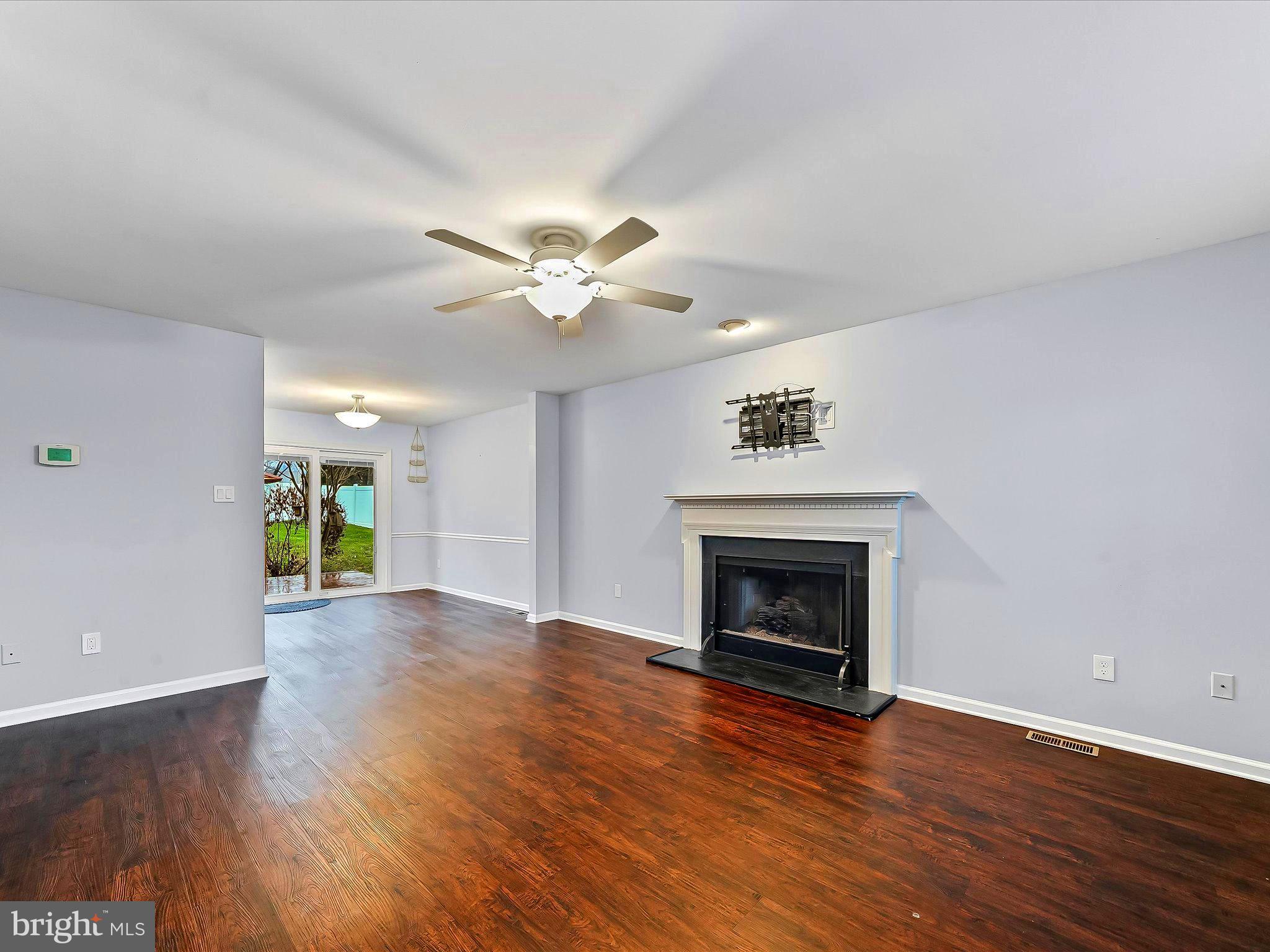 2410 Larkin Road Upper Chichester, PA 19061 - Photo 11 of 50 an empty room with wooden floor fireplace and windows