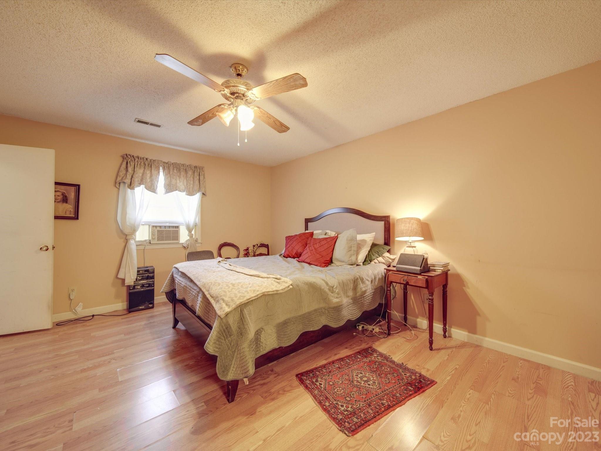 8009 Lighthouse Way Indian Trail, NC 28079 - Photo 13 of 26 a bedroom with a bed and wooden floor