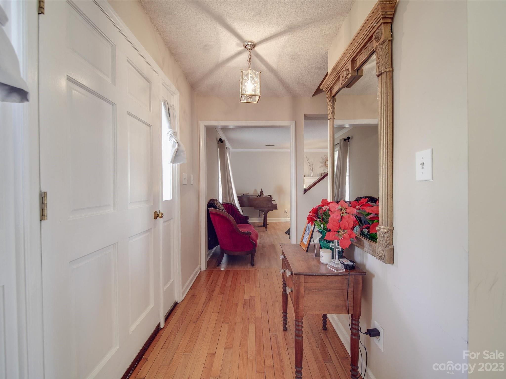 8009 Lighthouse Way Indian Trail, NC 28079 - Photo 4 of 26 a hallway with a flower pot and a bookshelf
