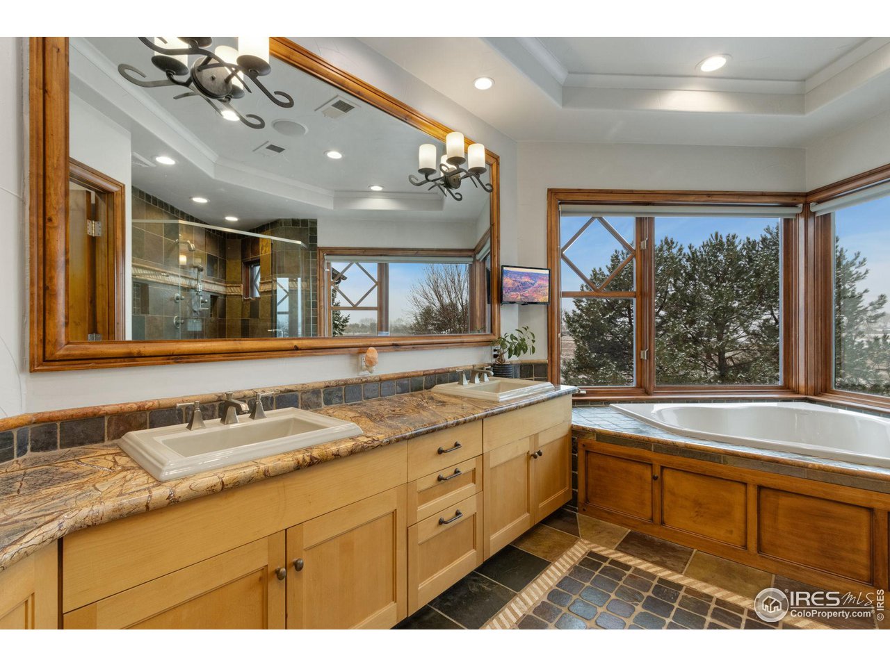 8467 Golden Eagle Road Fort Collins, CO 80528 - Photo 23 of 40 a bathroom with a sink a large mirror and a bathtub
