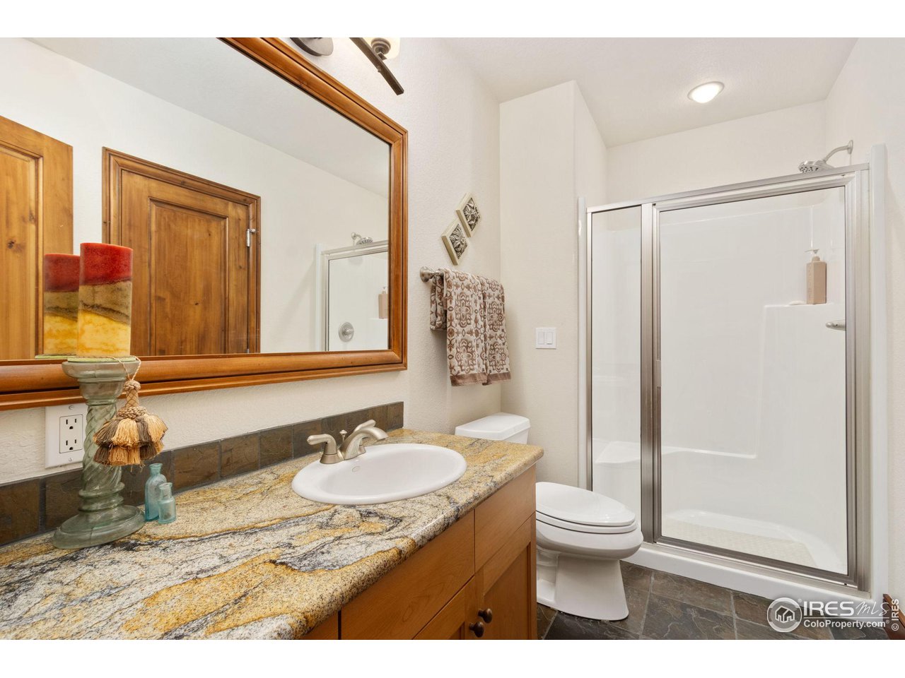 8467 Golden Eagle Road Fort Collins, CO 80528 - Photo 35 of 40 a bathroom with a granite countertop sink toilet and shower