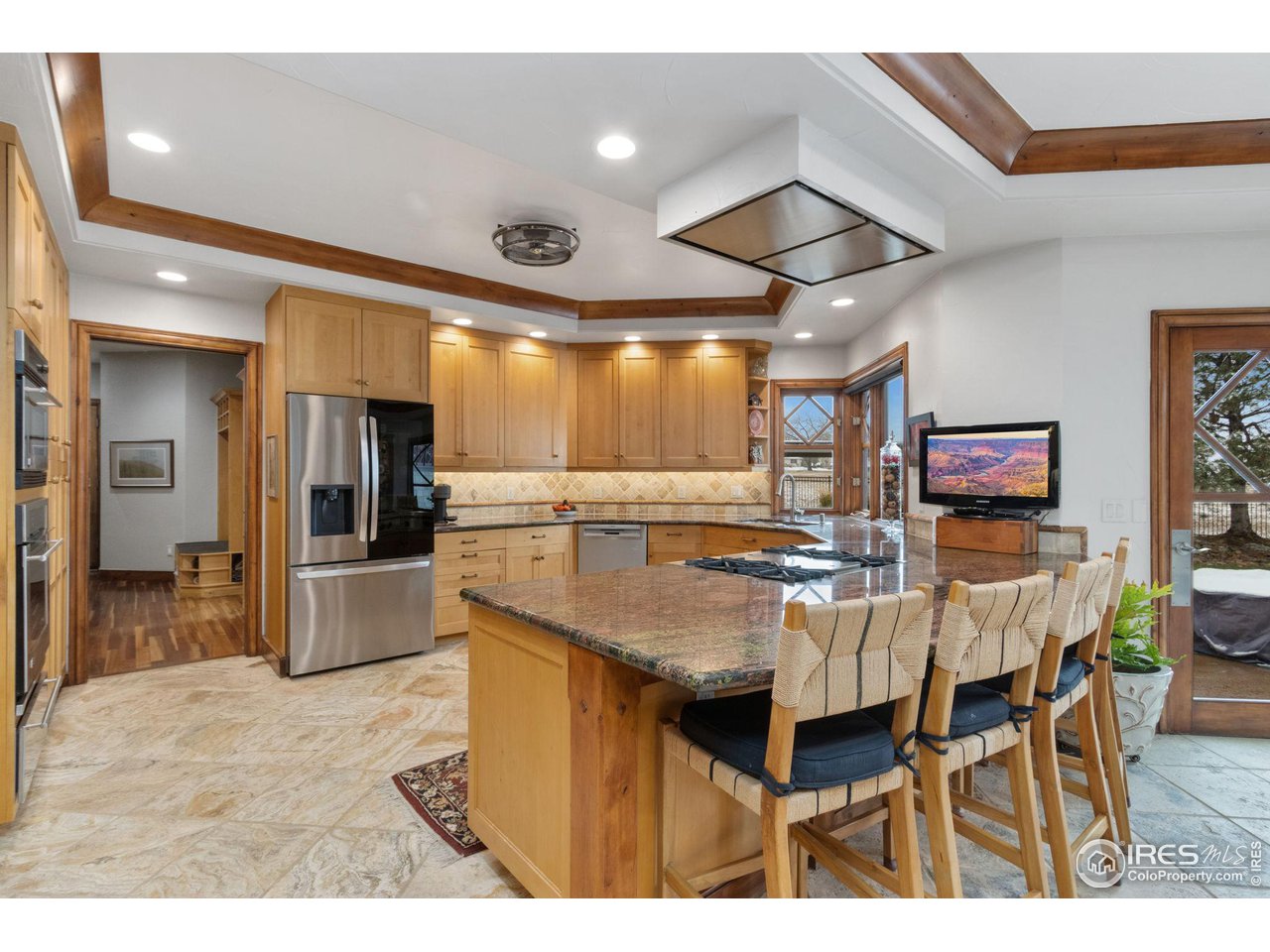 8467 Golden Eagle Road Fort Collins, CO 80528 - Photo 8 of 40 a kitchen with stainless steel appliances kitchen island granite countertop a table chairs and a refrigerator