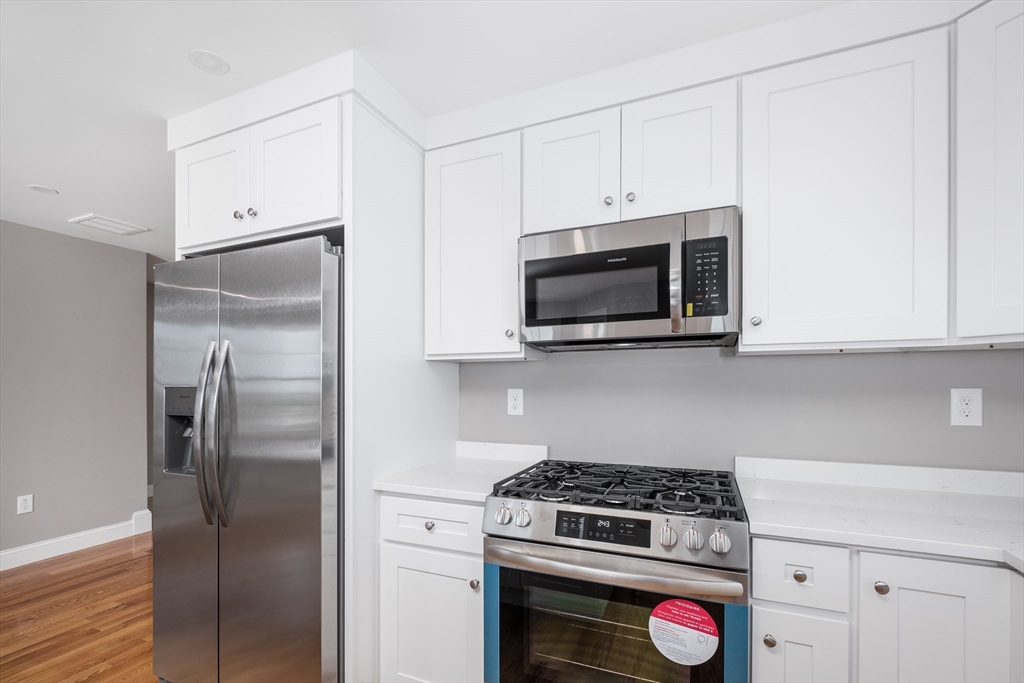 216 Vane Street, Unit 1 Revere, MA 02151 - Photo 2 of 22 a kitchen with white cabinets and stainless steel appliances