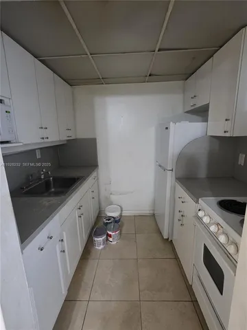 a kitchen with a sink dishwasher stove and cabinets