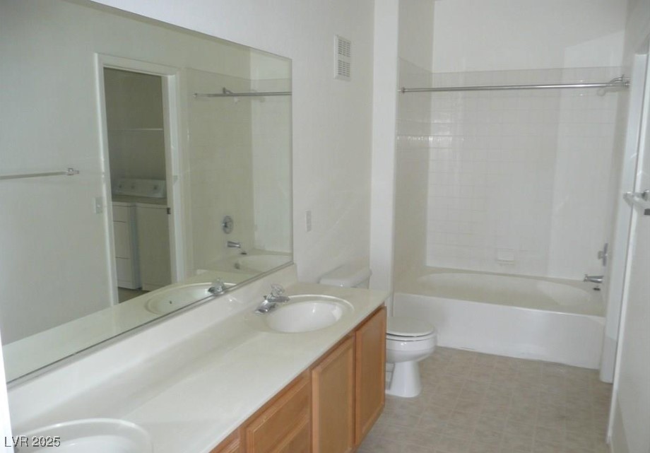 8725 West Flamingo Road, Unit 226 Las Vegas, NV 89147 - Photo 7 of 7 Full bathroom featuring bathing tub / shower combination, double vanity, and separate washer and dryer