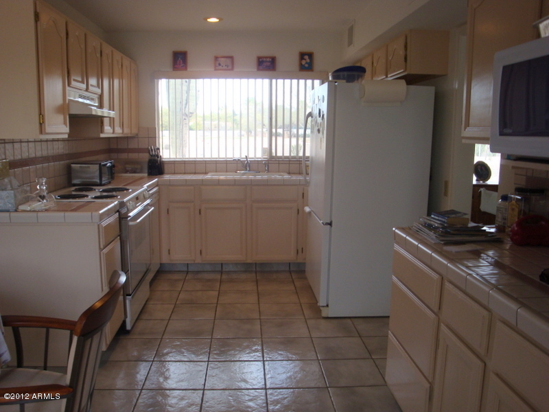 6933 East Doubletree Ranch Road Paradise Valley, AZ 85253 - Photo 13 of 30 a kitchen with a cabinets and a stove top oven
