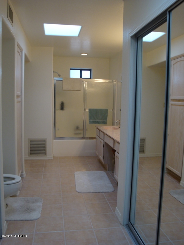 6933 East Doubletree Ranch Road Paradise Valley, AZ 85253 - Photo 28 of 30 a bathroom with a glass door shower a sink and a toilet
