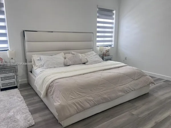 a large bed sitting in a bedroom next to a window