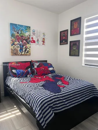 a bedroom with a bed and a painting on the wall