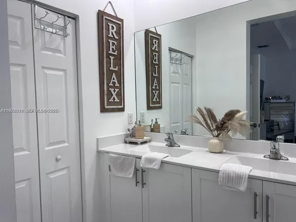 a bathroom with double sink and a mirror
