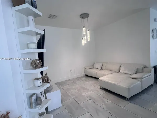 a living room with furniture and a mirror