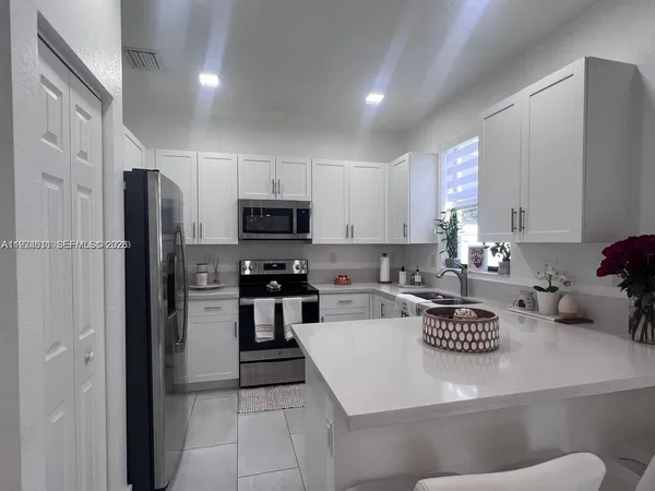 a kitchen with a refrigerator a stove a sink and a counter top space