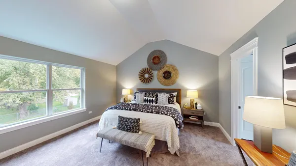 a bedroom with a bed and a large window