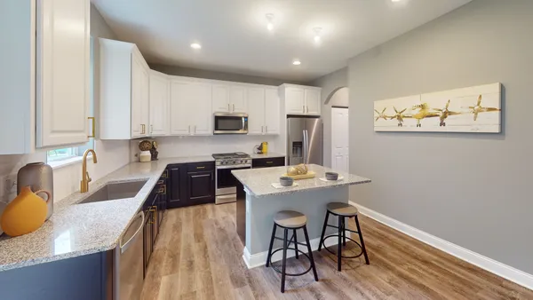 a kitchen with kitchen island a stove a table and chairs
