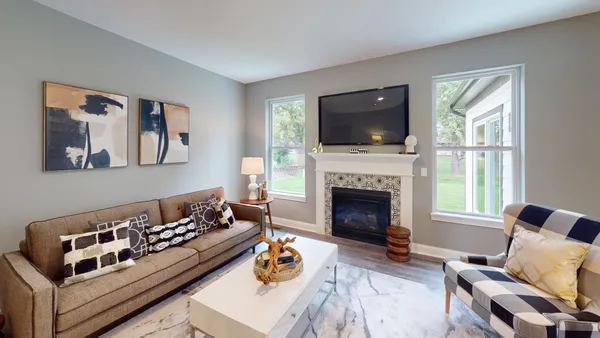 a living room with furniture a flat screen tv and a fireplace
