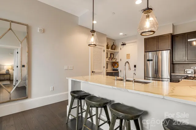 a kitchen with granite countertop a table chairs refrigerator and microwave