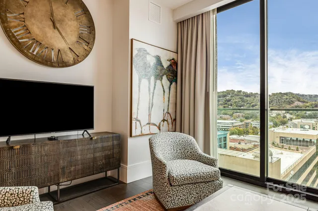 a living room with furniture a large window and a flat screen tv
