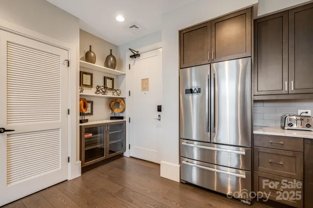 a metallic refrigerator freezer sitting in a kitchen