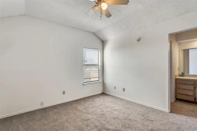 an empty room with wooden floor ceiling fan and windows