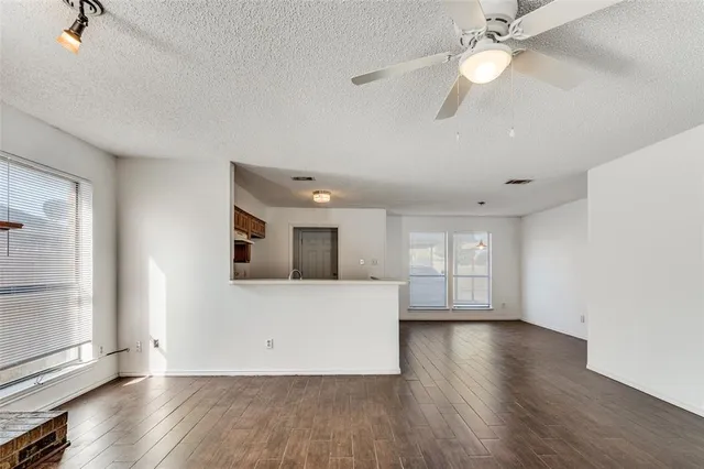 a view of a livingroom with wooden floor and a ceiling fan
