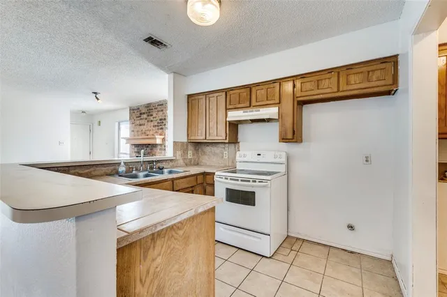 a view of a kitchen with wooden floor and a refrigerator