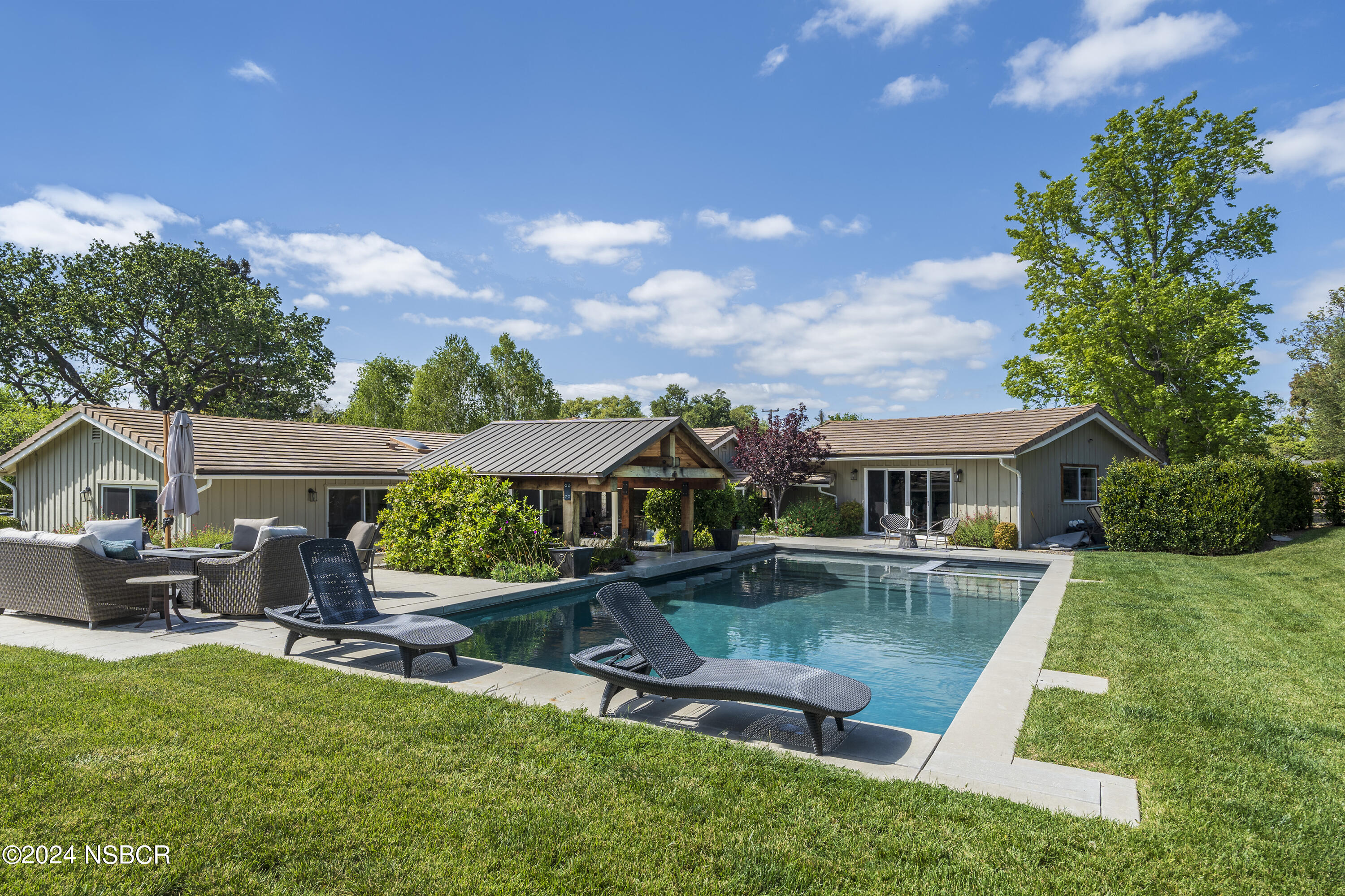 a view of house with swimming pool yard fire pit and outdoor seating