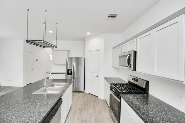 a kitchen with granite countertop stainless steel appliances and wooden cabinets