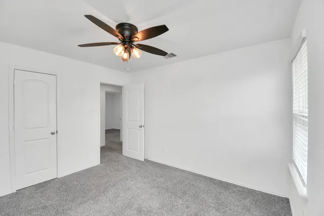 a view of an empty room and a ceiling fan