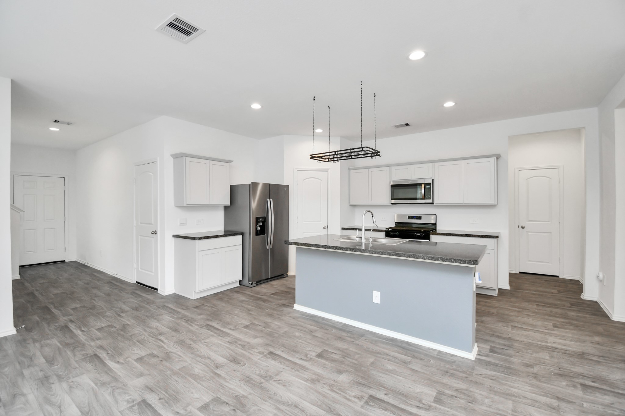 5443 Pinetree Crescent Ln Spring Spring, TX 77373 - Photo 9 of 43 a kitchen with stainless steel appliances kitchen island granite countertop a refrigerator a stove a sink and white cabinets with wooden floor