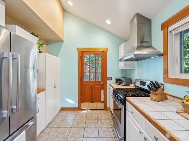 a kitchen with stainless steel appliances granite countertop a refrigerator and a stove