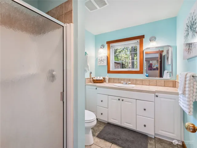 a spacious bathroom with a granite countertop sink toilet a large mirror a bathtub and window