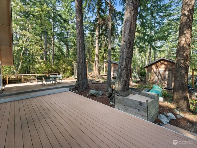 a view of a balcony with chairs and wooden fence