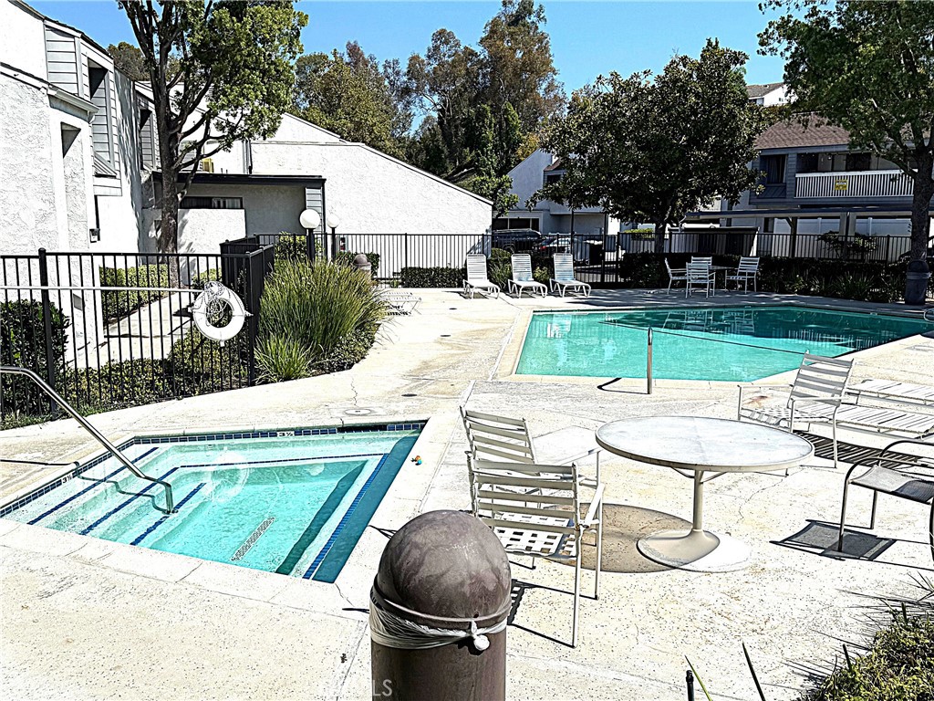 545 South Ranch View Circle, Unit 97 Anaheim Hills, CA 92807 - Photo 29 of 33 a view of a patio with table and chairs with wooden floor and fence