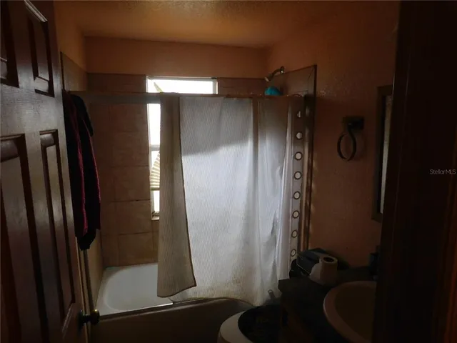 a bathroom with a shower and a sink