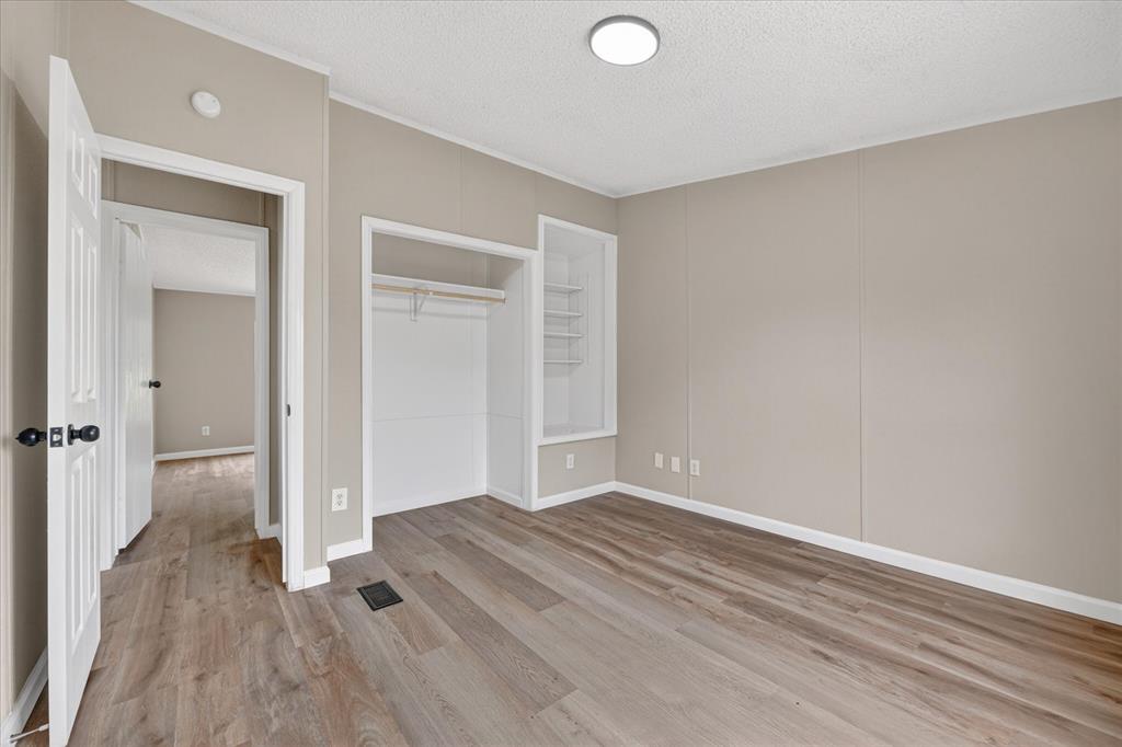 134 Classic Country Court Springtown, TX 76082 - Photo 17 of 35 Spacious room featuring wood-finish flooring, neutral-toned walls, and white trim