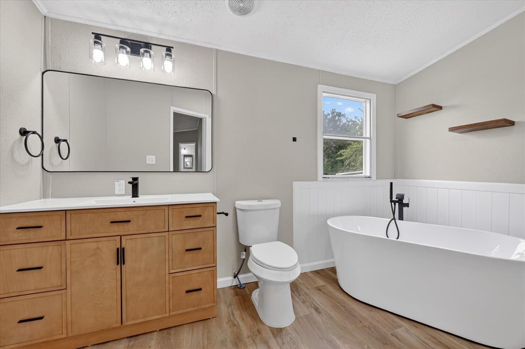 134 Classic Country Court Springtown, TX 76082 - Photo 26 of 35 Bathroom featuring a light wood-finish vanity with ample storage, a white countertop, and a rectangular mirror with black trim