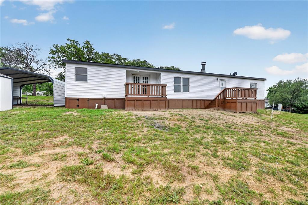134 Classic Country Court Springtown, TX 76082 - Photo 31 of 35 White siding exterior with a dark trim roofline