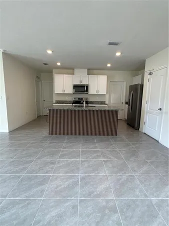 a kitchen with a refrigerator and a stove top oven