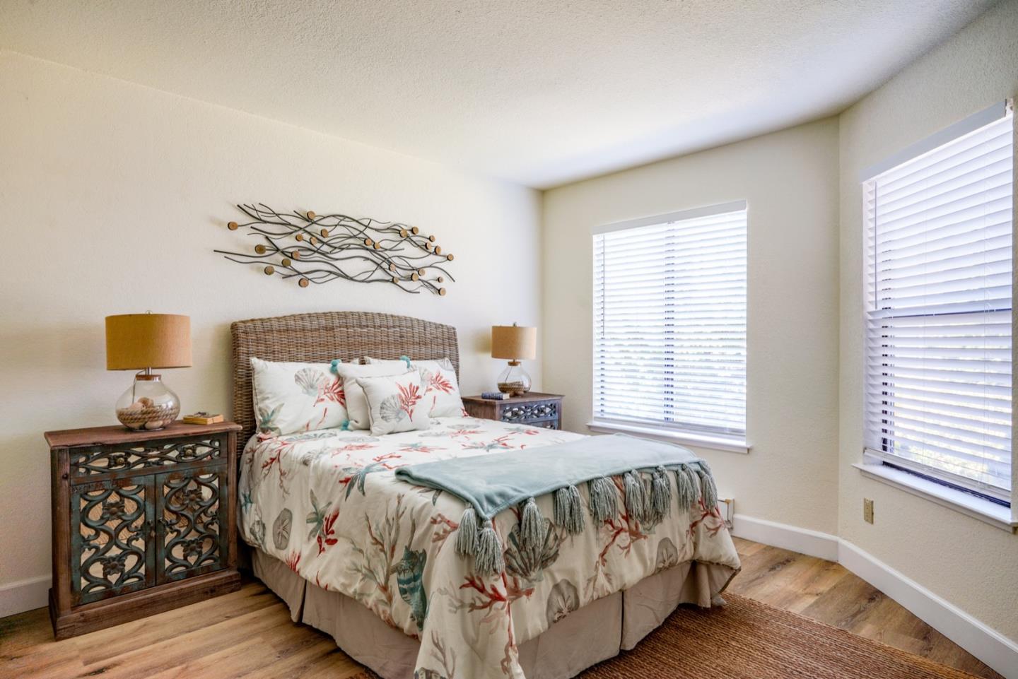 1 Surf Way, Unit 125 Monterey, CA 93940 - Photo 12 of 36 a bedroom with a bed and wooden floor