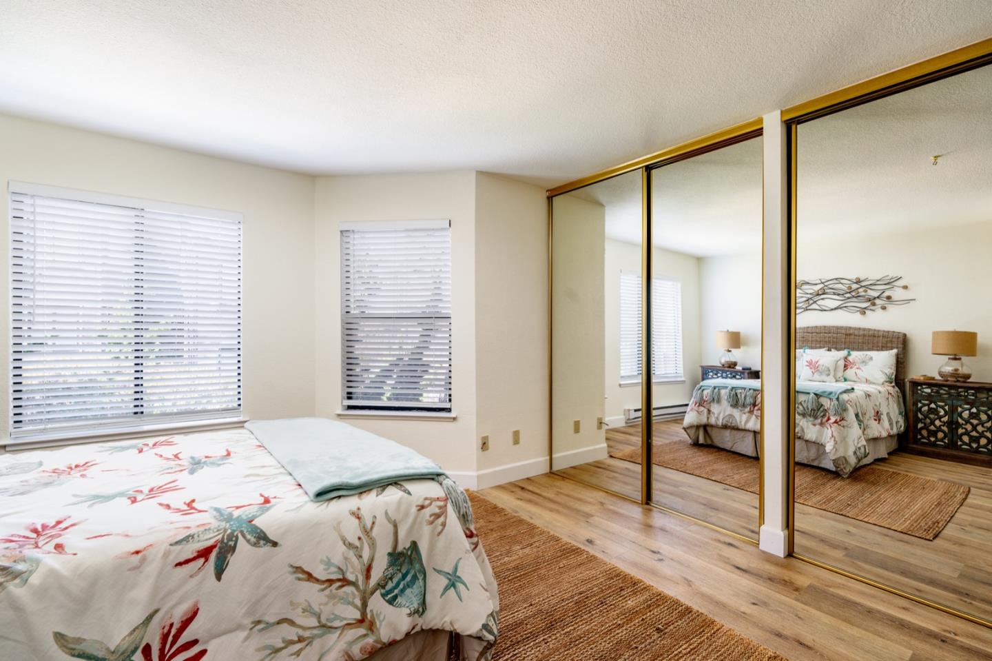 1 Surf Way, Unit 125 Monterey, CA 93940 - Photo 13 of 36 a bedroom with a bed and large window with wooden floor
