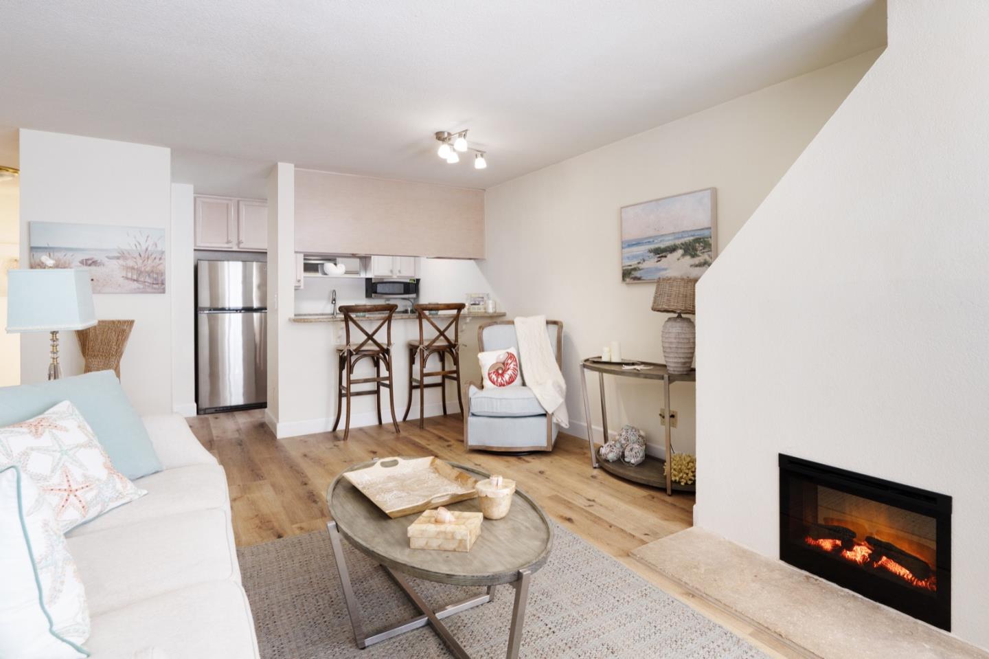 1 Surf Way, Unit 125 Monterey, CA 93940 - Photo 8 of 36 a living room with furniture and a flat screen tv