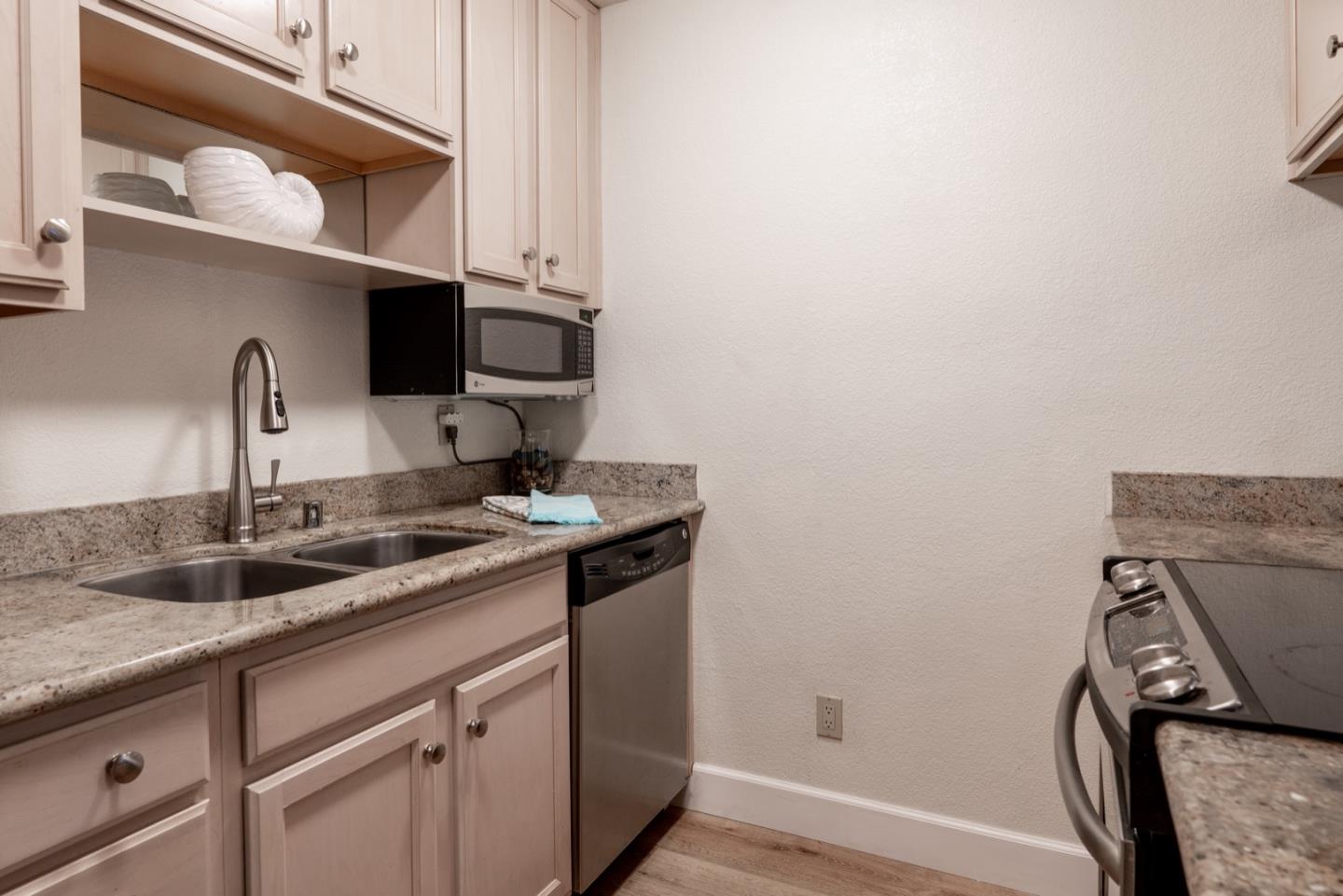 1 Surf Way, Unit 125 Monterey, CA 93940 - Photo 9 of 36 a kitchen with a sink and cabinets