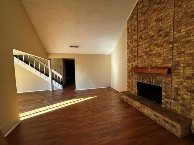 a view of a livingroom with wooden floor and a fireplace