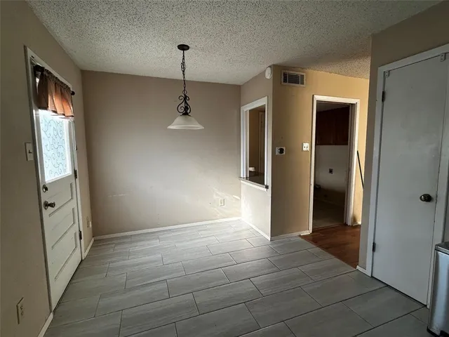 a view of an empty room with window and stairs