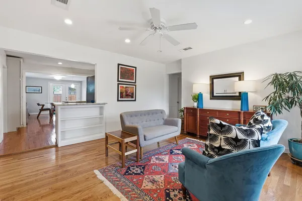 a living room with furniture and a wooden floor