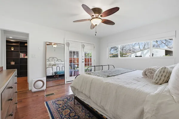 a bedroom with a bed a couch and a chandelier