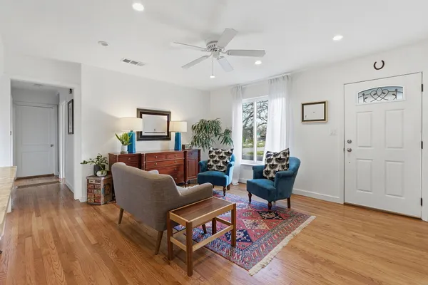 a living room with furniture and a wooden floor