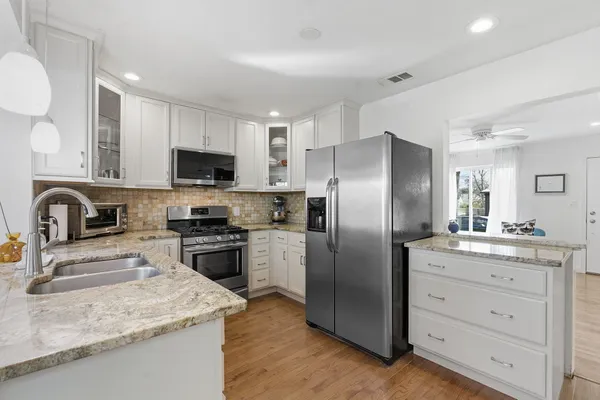 a kitchen with a refrigerator sink and wooden cabinets