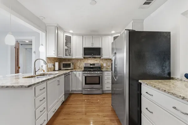 a kitchen with granite countertop a refrigerator and a sink