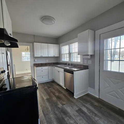 a kitchen with granite countertop a sink cabinets and stainless steel appliances